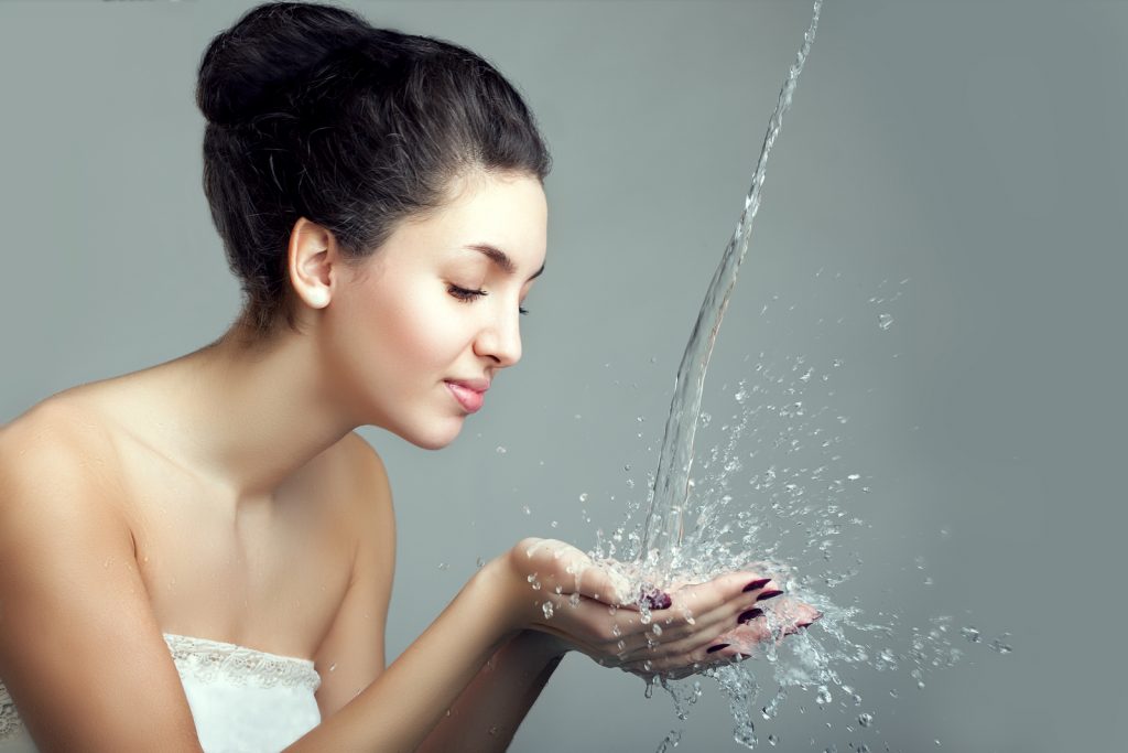 Woman and water splash. Water drops and bubbles in girls hands.